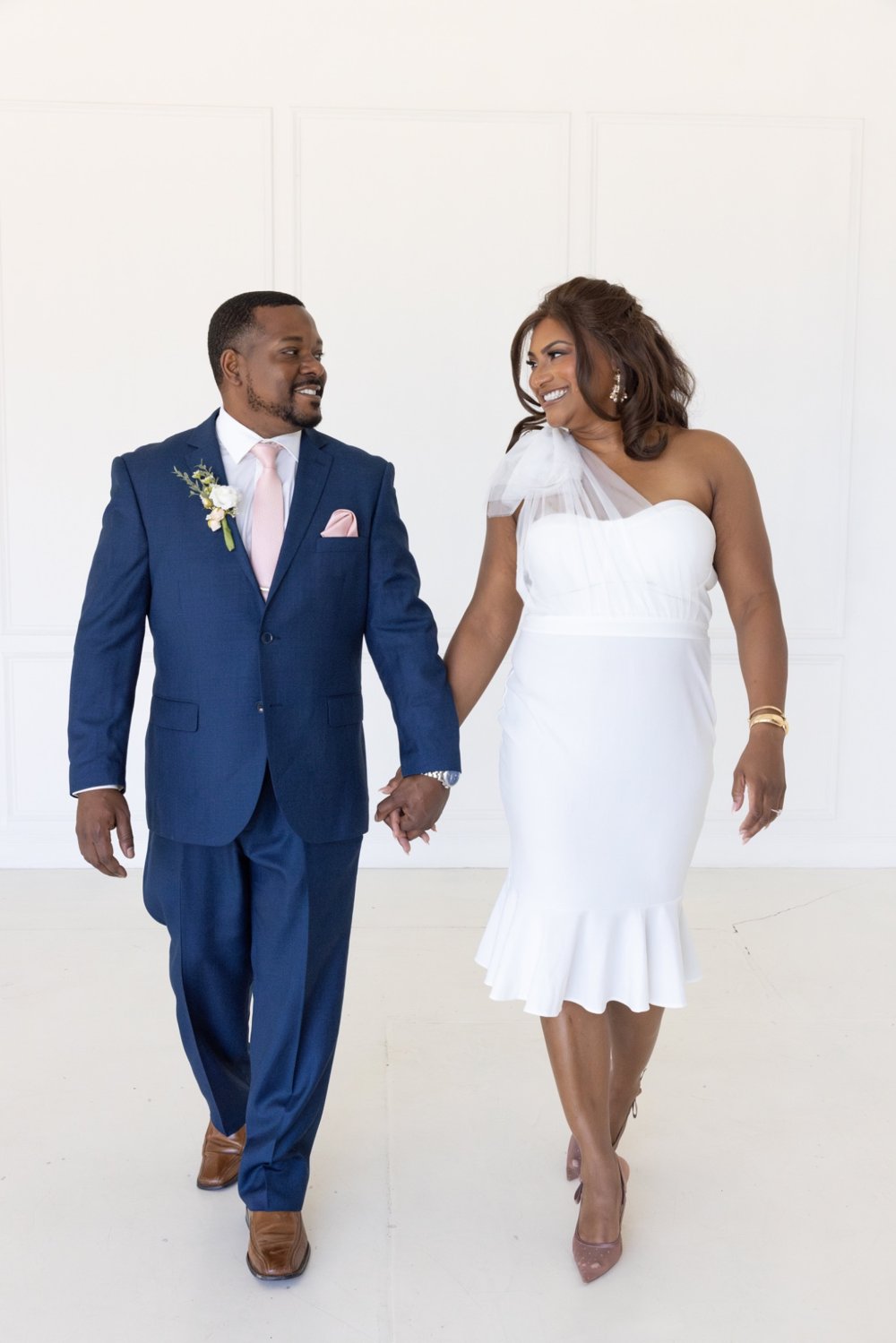 Ericka and Alex holding hands and smiling at one another